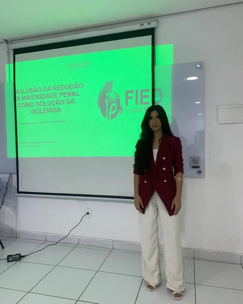 Vanessa Britto diante de uma apresentação acadêmica durante sua formação em Direito